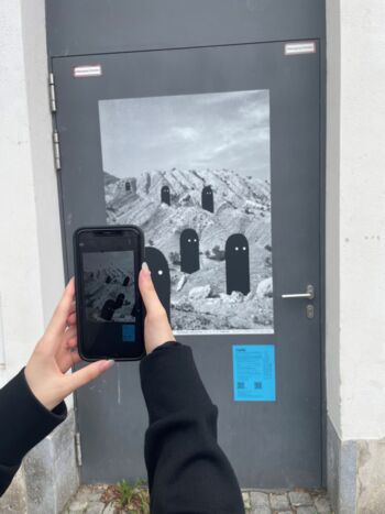 Durch eine App auf dem Smartphone wird ein Plakat, das an einer Tür zum Prediger hängt, virtuell zum Leben erweckt
